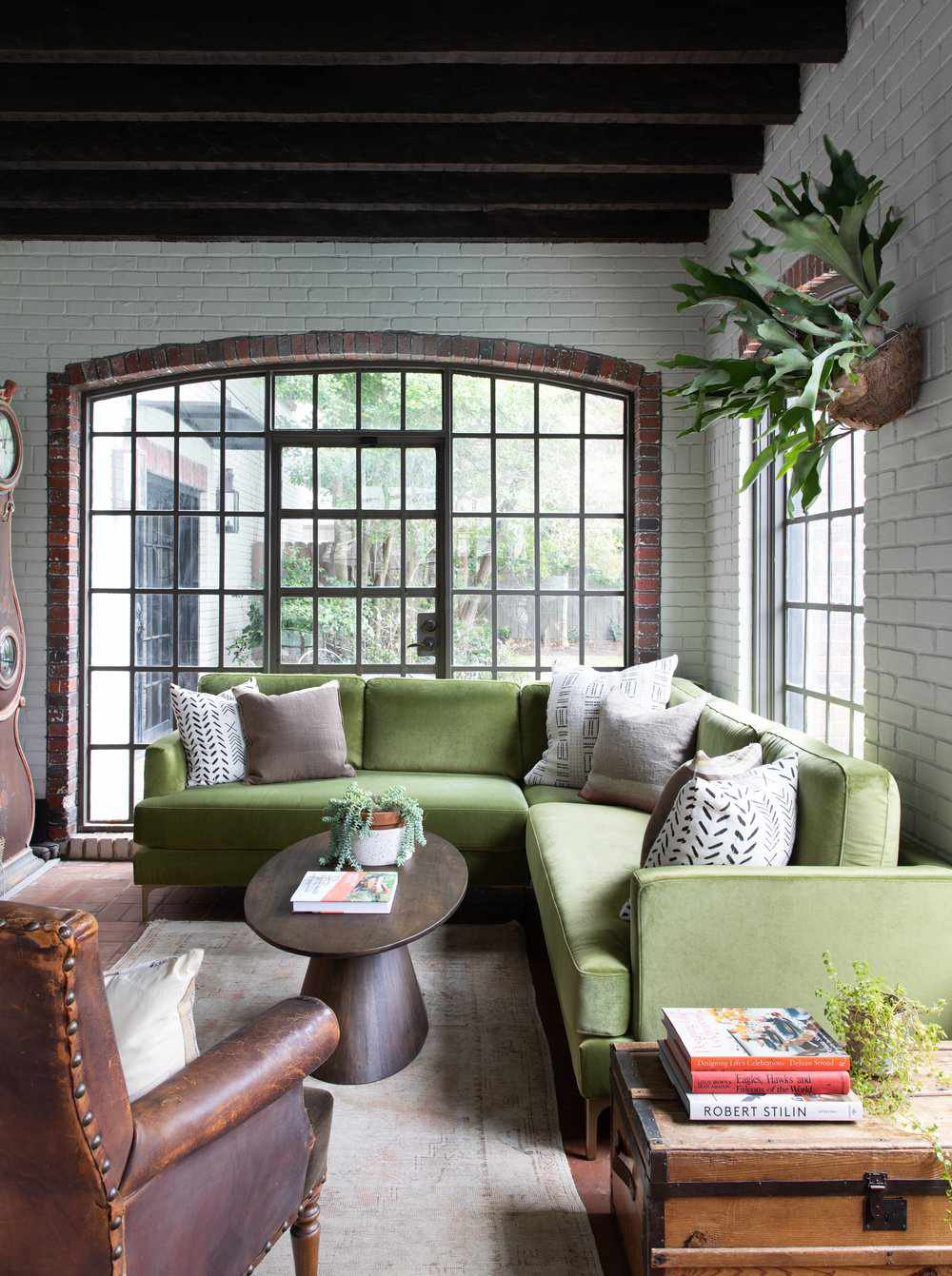 48 Small Sunroom Ideas for a Warm and Happy Space 52 Sunroom with white painted brick walls, wood ceiling beams and a green sectional