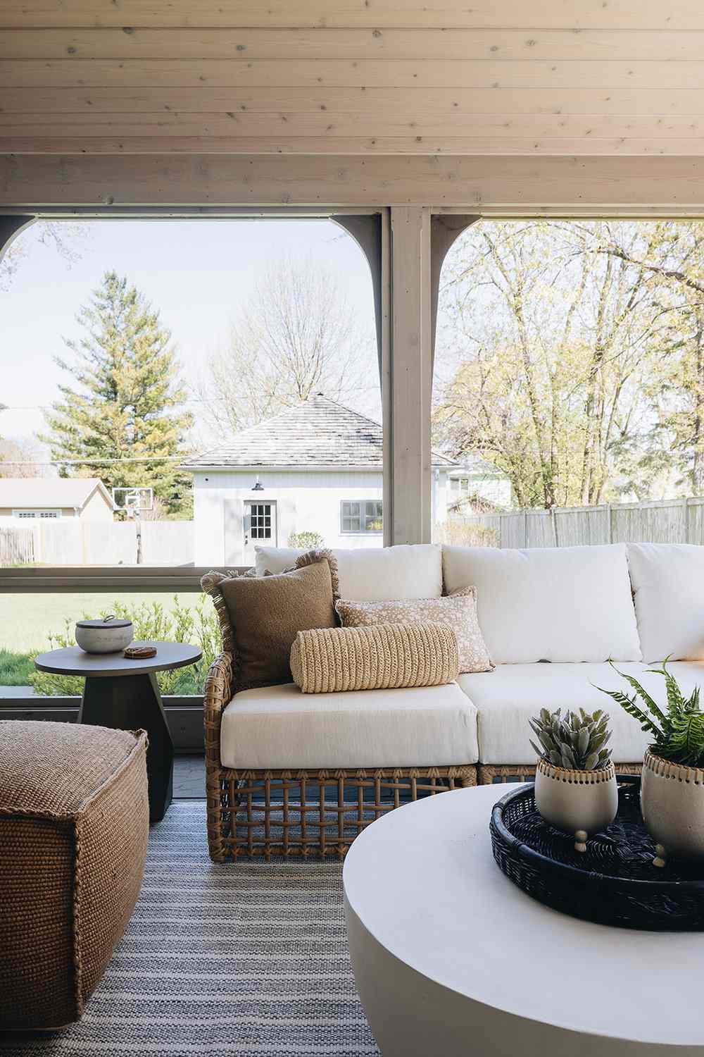 48 Small Sunroom Ideas for a Warm and Happy Space 82 Rattan furniture with white cushions and a round stone coffee table in a sunroom