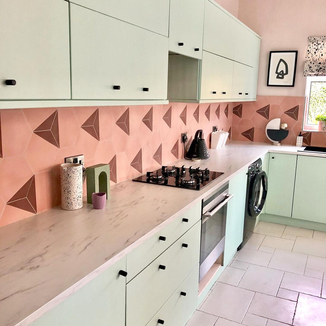 10 geniale Möglichkeiten, um einer stumpfen Küche einen Farbtupfer hinzuzufügen, teilen Designer 12 Eine Küche im Retro -Stil mit rosa geometrischen Backsplash -Fliesen und Minzgrün -Schränken