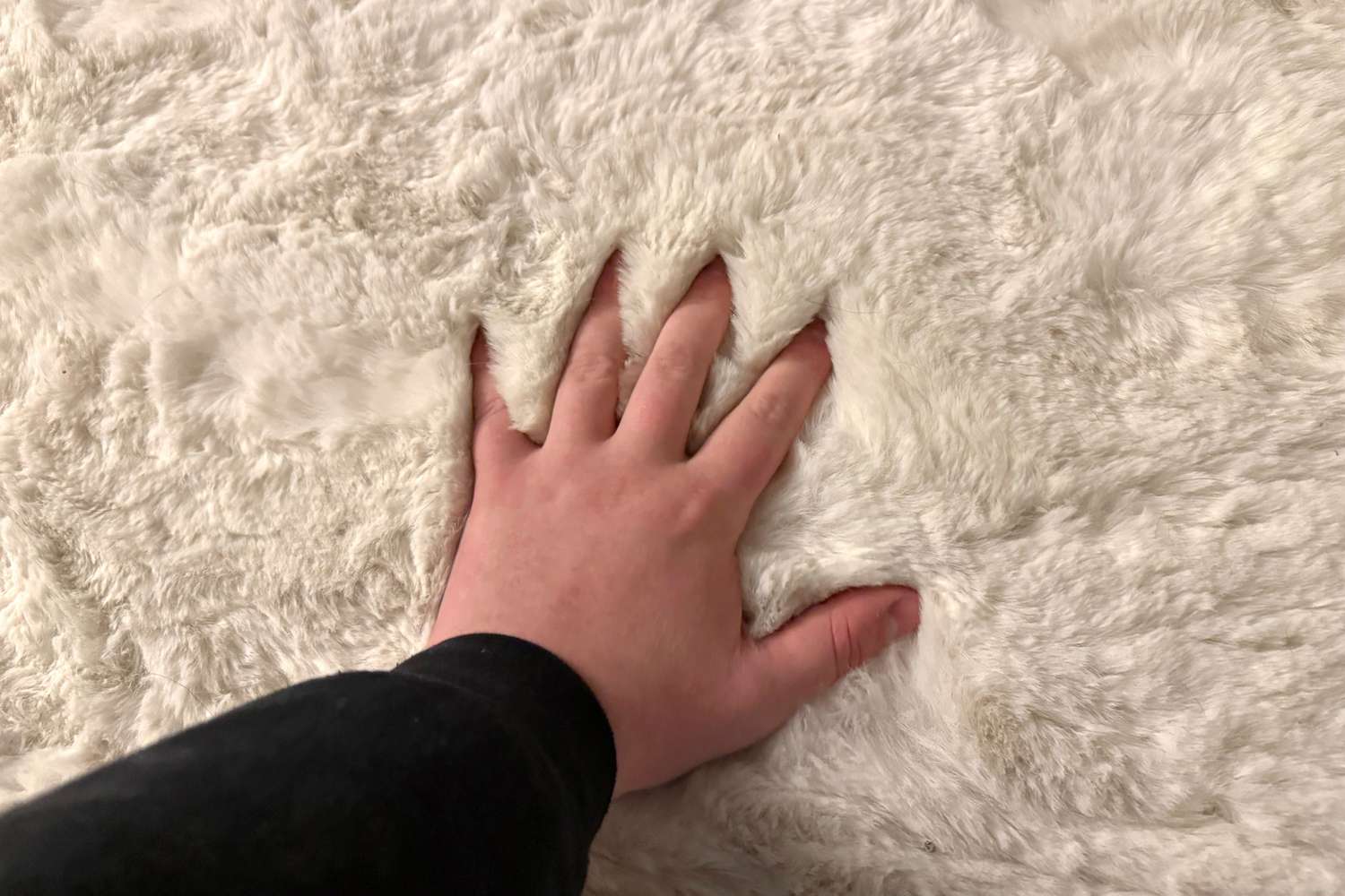 Eine Hand, die auf die Teppiche drückt, USA Waverly Double Faux Sheepell Teppich
