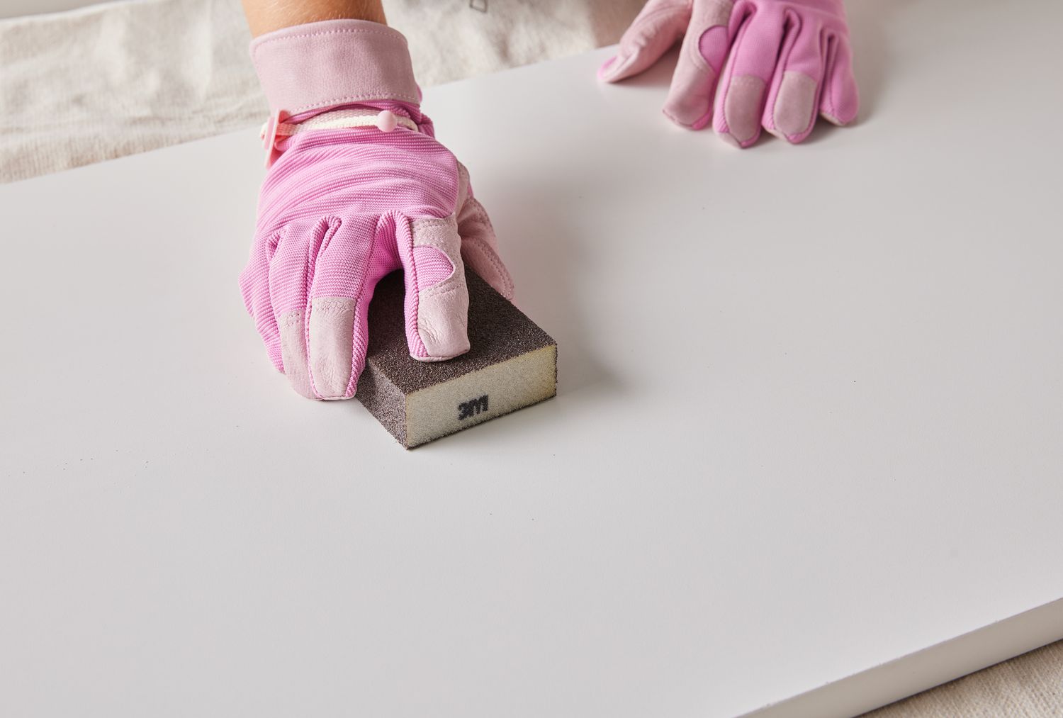 Leicht Sand und sauberes Holz mit Handschuhen