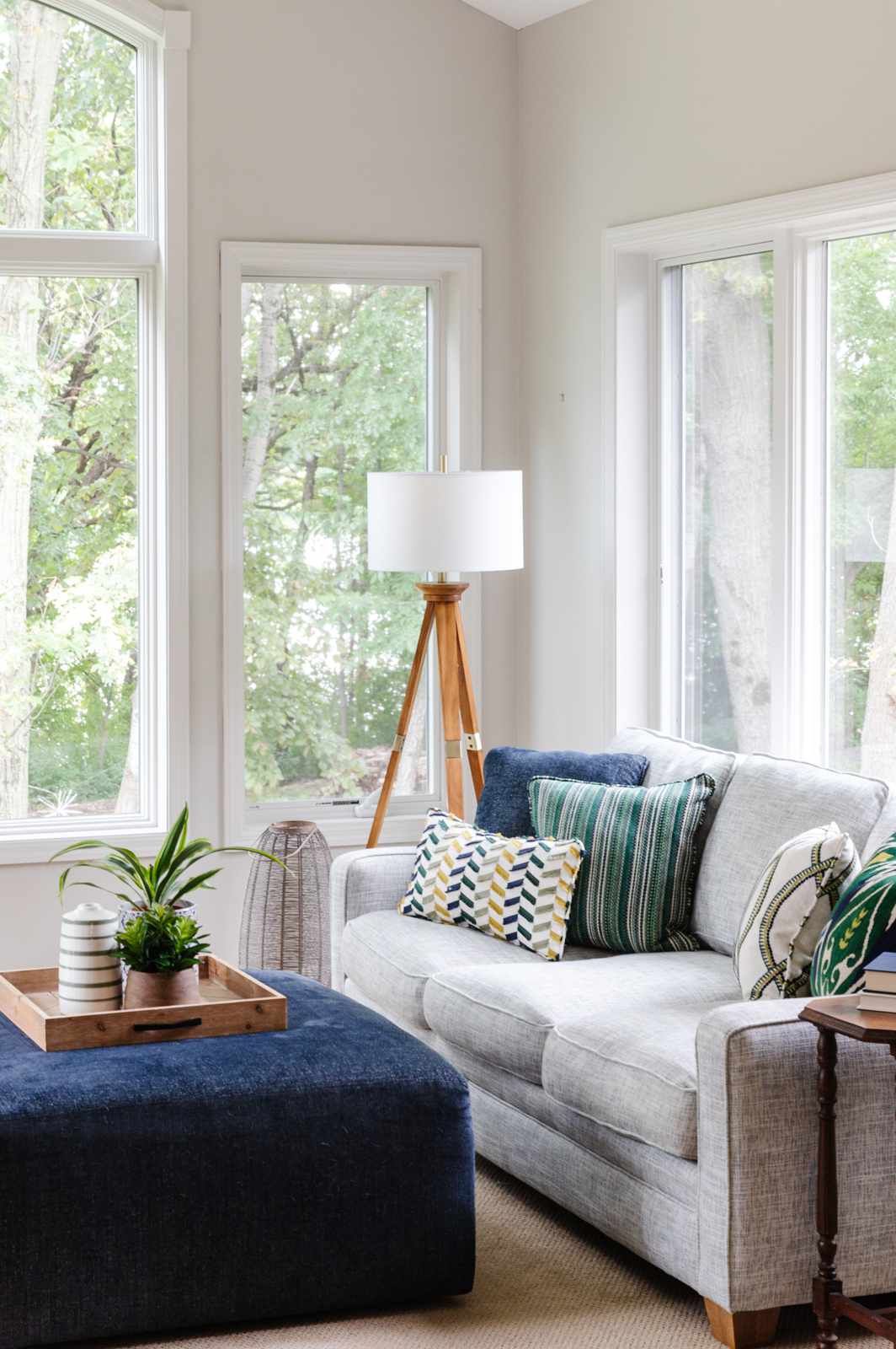 48 Small Sunroom Ideas for a Warm and Happy Space 2 Gray sofa and blue ottoman coffee table in a sunroom with light gray walls
