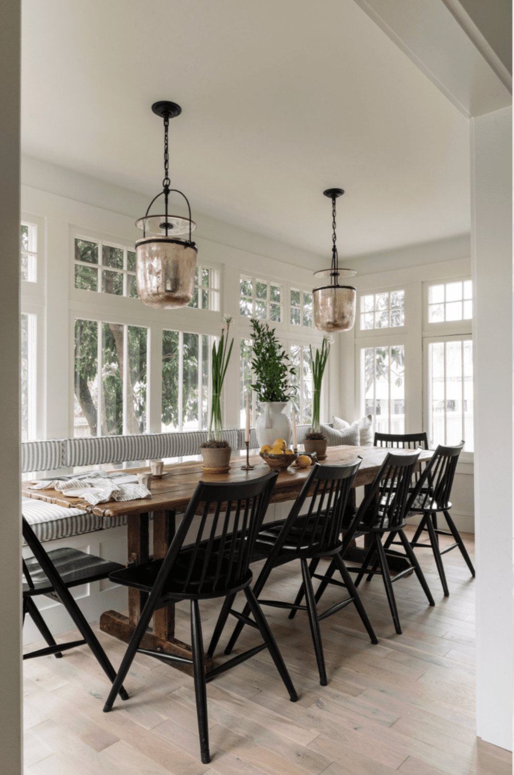 48 Small Sunroom Ideas for a Warm and Happy Space 10 Sunroom used as an elegant dining room with a long table and two pendant lights