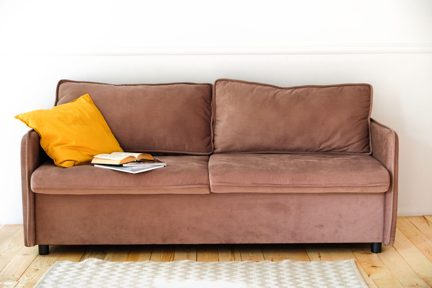 6 Couch -Stile, die laut Designer so veraltet sind 6 Braune Wildleder -Couch mit einem gelben Kissen