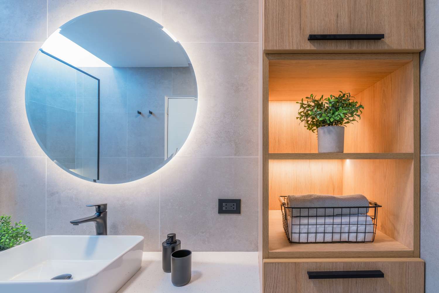 Modernes Badezimmer mit LED -Beleuchtung am Spiegel und in Regalen