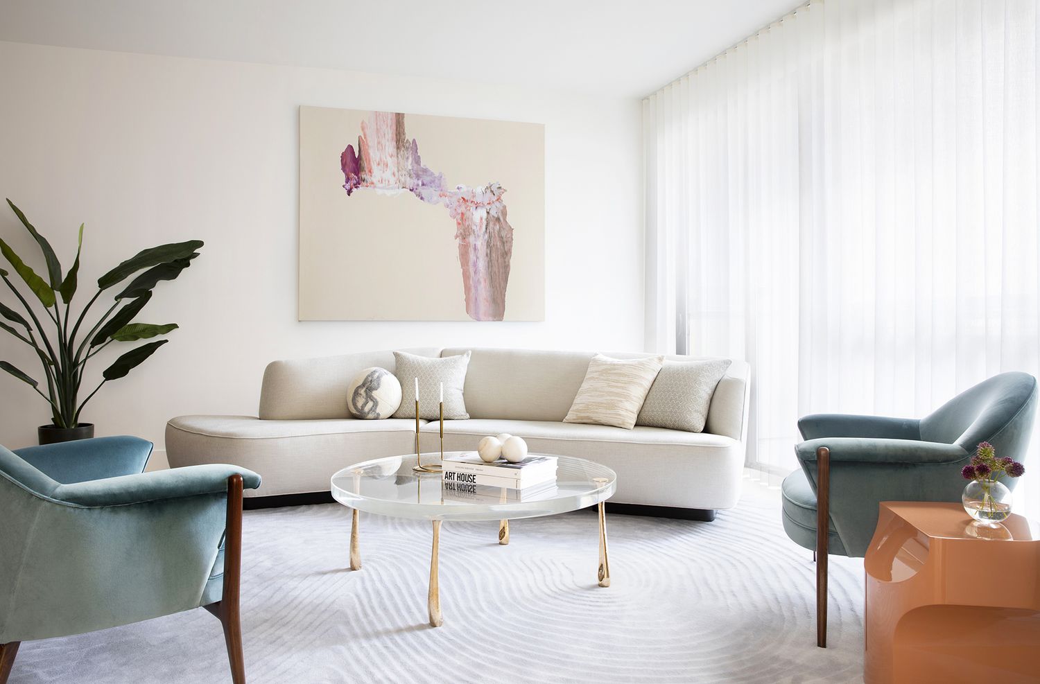 Abgerundete Couch, Stühle, Tisch und Teppich in einem Wohnzimmer