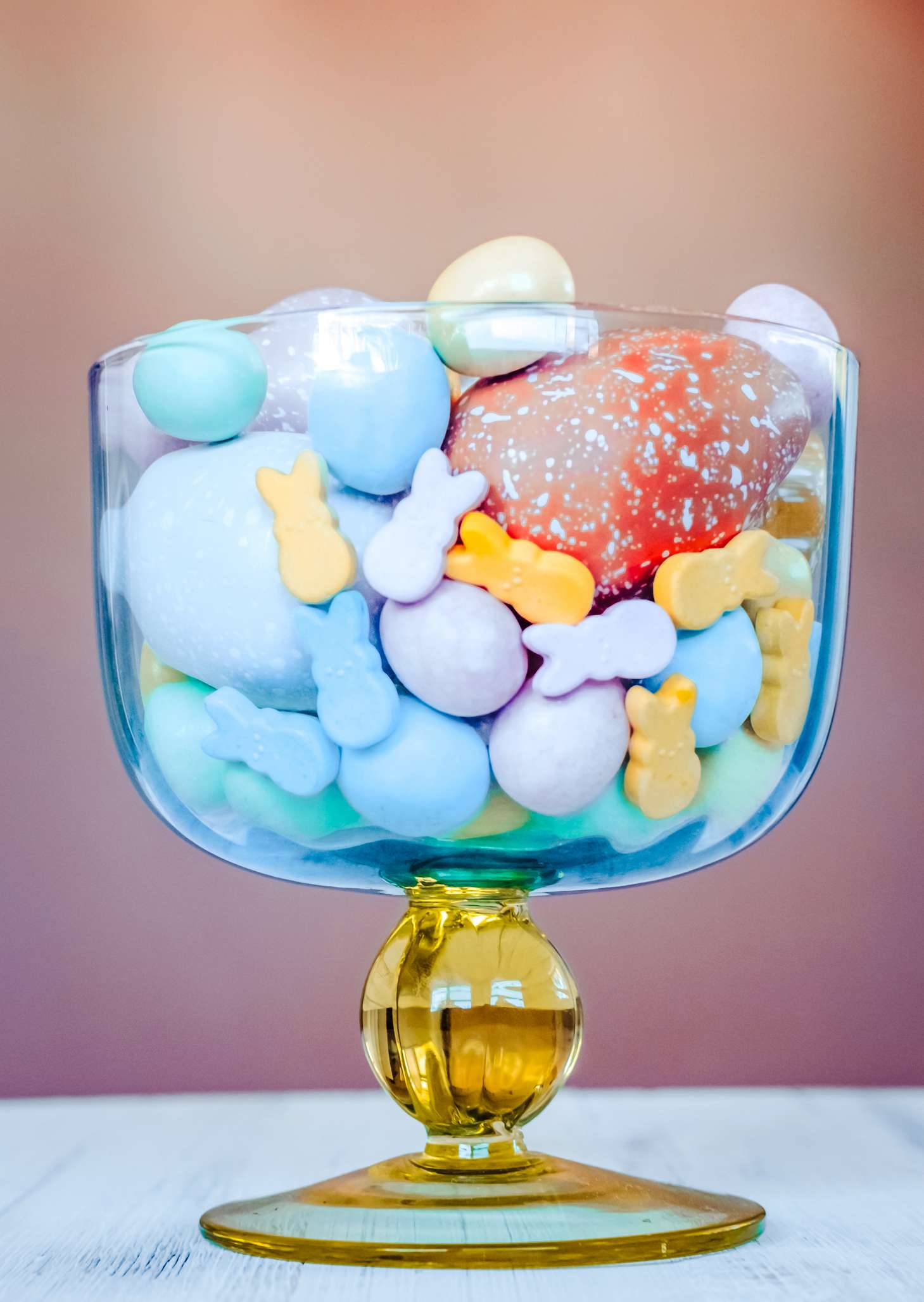 Ostern süße Süßigkeiten und pastellfarbene Eier in einem schönen Vintage -Glas -Coupé. Osterfeier Konzept.