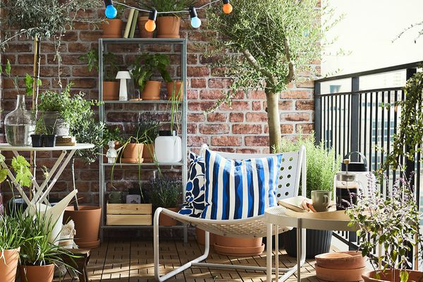 Terrasseszene mit Stuhl und gestreiftem Kissen, umgeben von Pflanzen