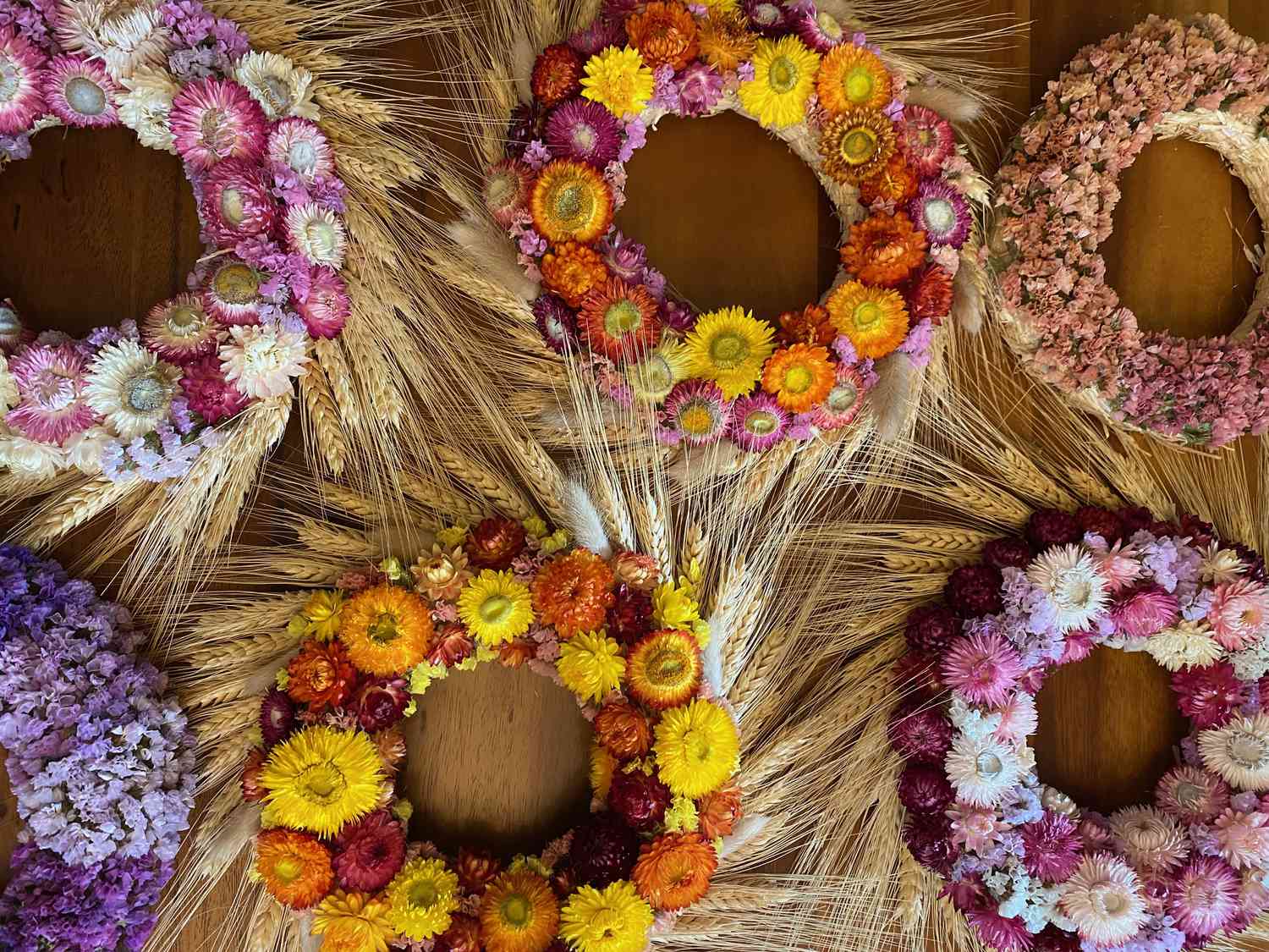 Sechs getrocknete Blumenkränze auf einer Tischplatte