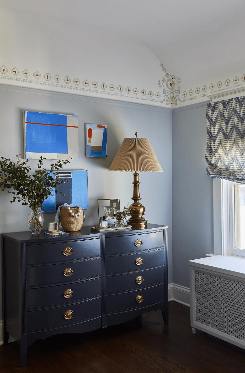 Vintage Eclectic Schlafzimmer mit dunkelblau gestrichener Bundeskommode mit einer übergroßen Mitte des Jahrhunderts Messinglampe