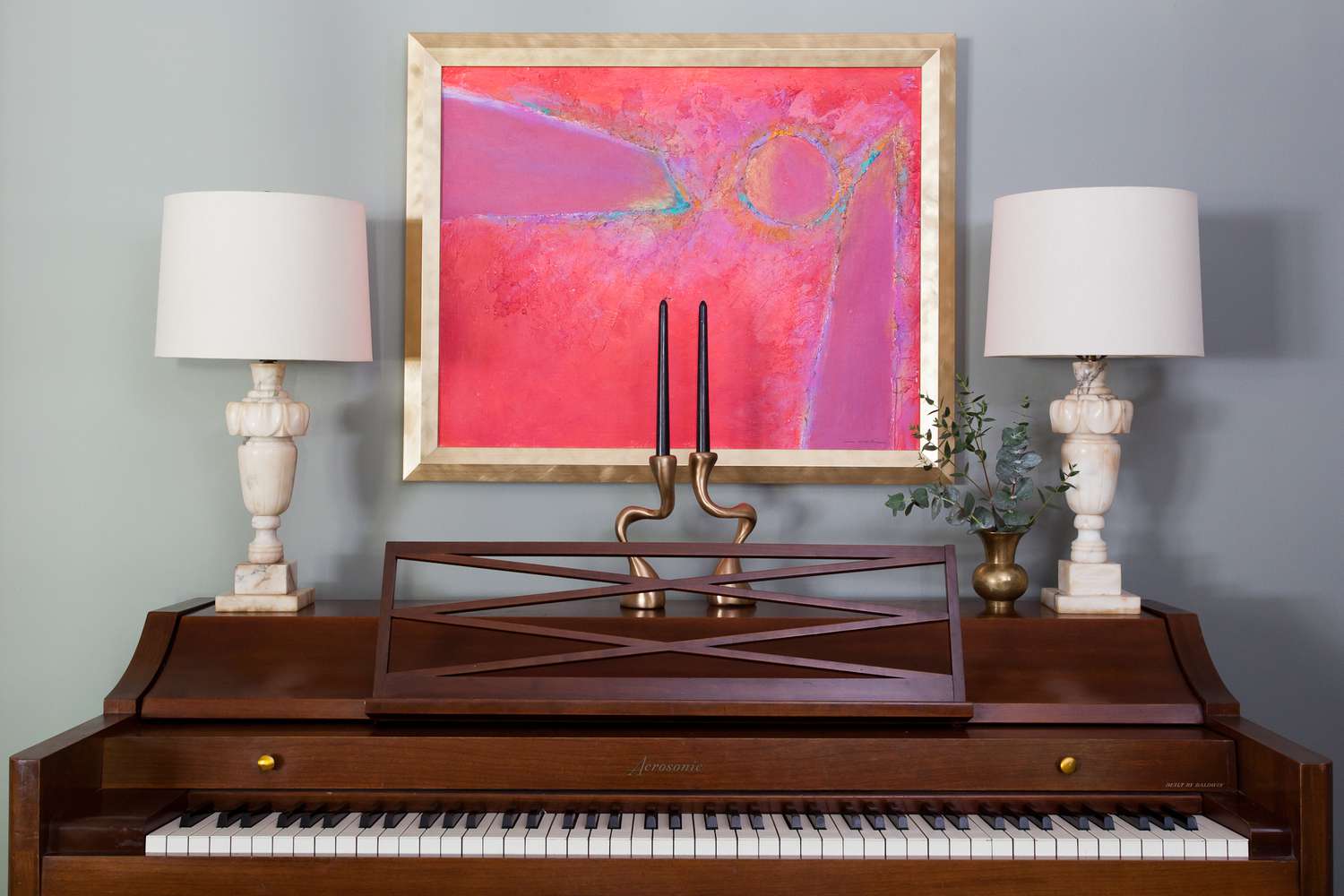 Vintage Eclectic Piano Vignette mit pinkfarbenem Malerei und weiße Alabaster -Lampen 