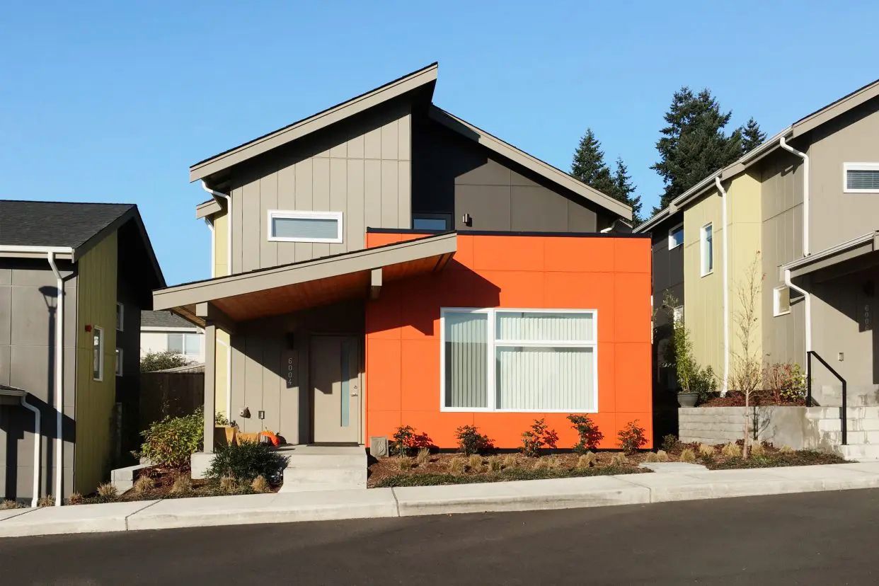 contemporary cottage with muted sage green painted exterior