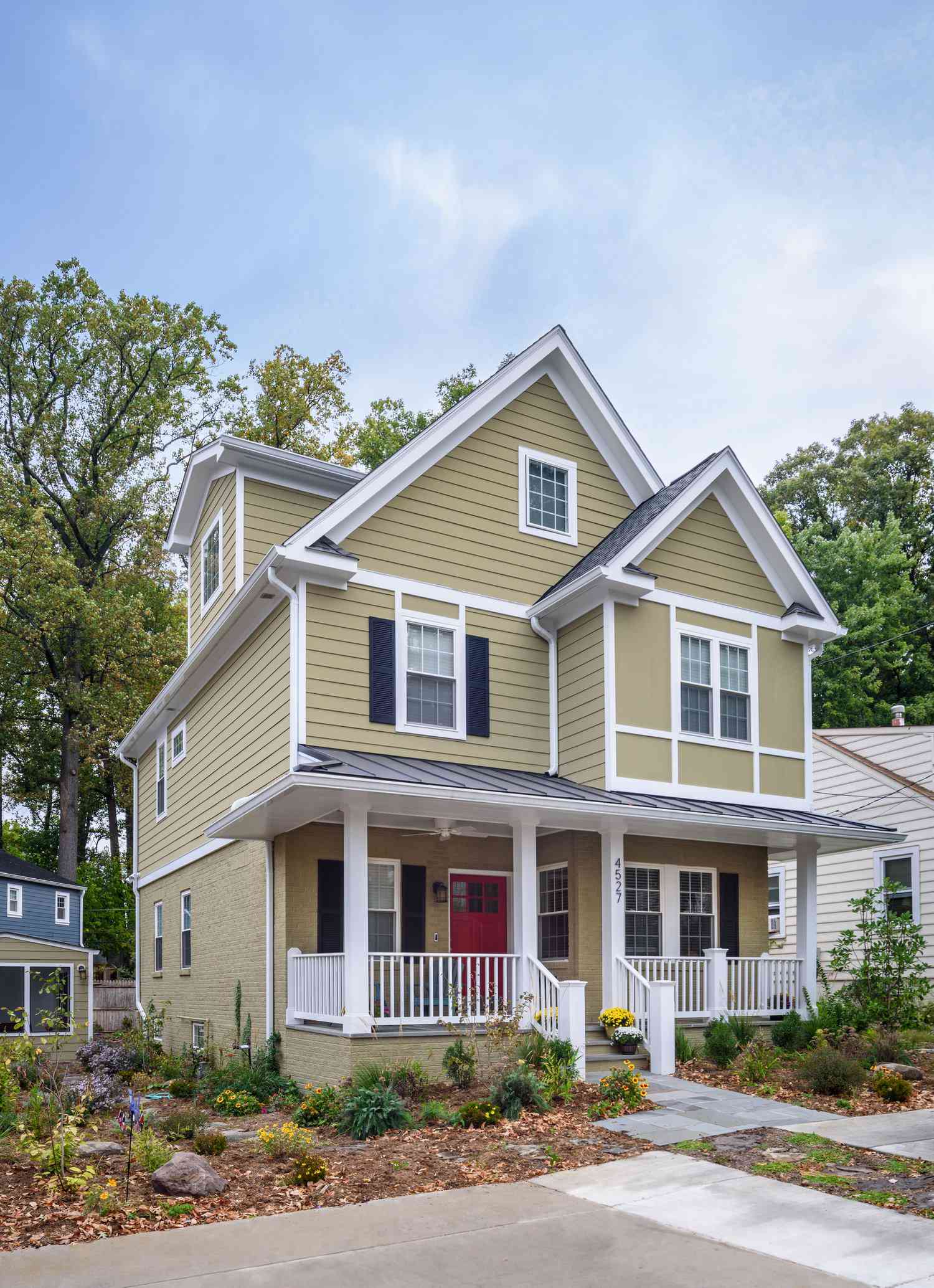 sage green house with white trim and black shutters
