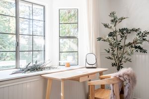 Wir haben Designer gefragt, ob Sie Vorhänge offen lassen sollten, wenn Sie weg sind, und sie haben sich nicht zurückhalten 6 Ein Holzschreibtisch von Lorbefenstern mit Licht kommt durch
