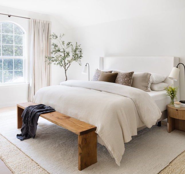 8 Designer-Approved Bedroom Decorating Tricks That Cost Less Than They Look 12 Earthy bedroom with a rustic wood bench.