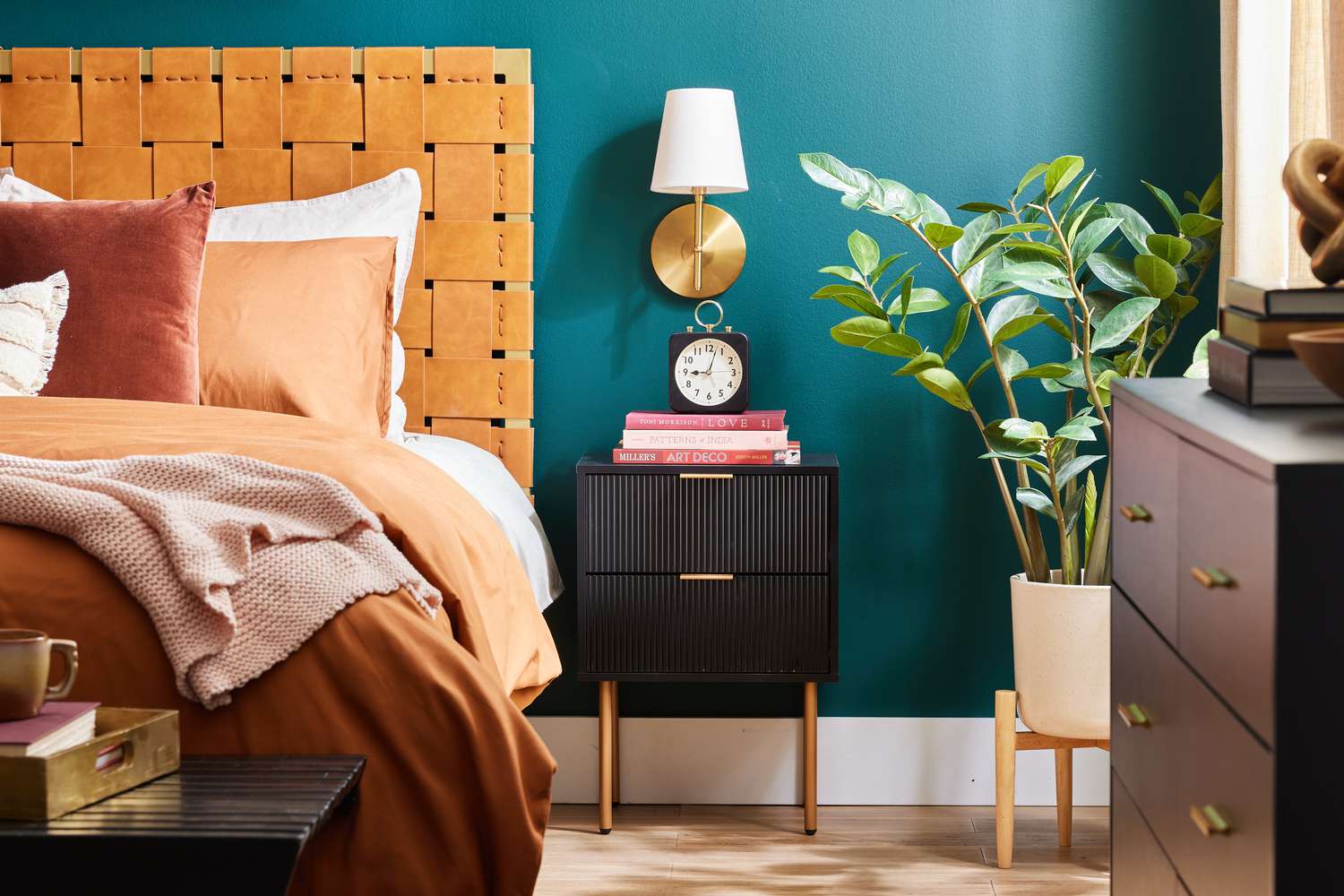 8 Designer-Approved Bedroom Decorating Tricks That Cost Less Than They Look 16 Teal bedroom with lattice leather headboard, black and brass nightstand, and a potted rubber plant