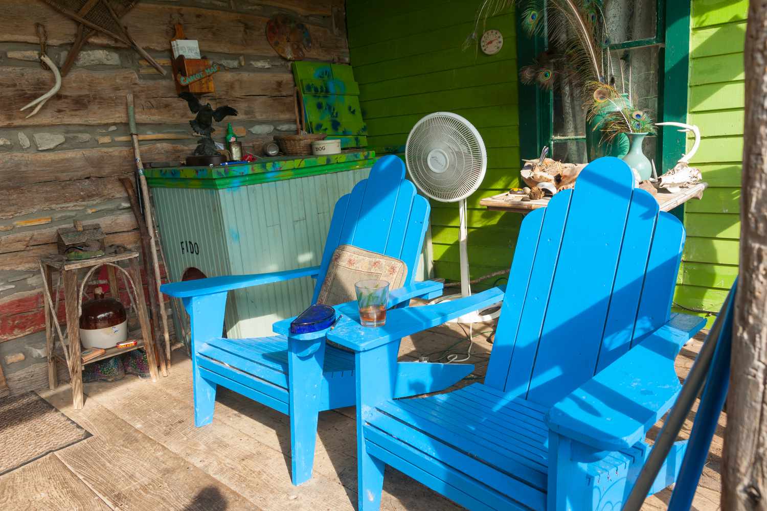 Designers Have Spoken: These Front Porch Features Are Always Eyesores 2 Cluttered porch with Adirondack chairs, too much decor, and a dog house.