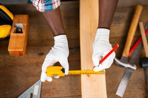 Warten Sie, werfen Sie Ihre alten Nägel nicht weg - 7 kluge Möglichkeiten, um sie in Ihrem Haus wiederzuverwenden 2 Mann, der ein Stück Holz für Home Reno -Projekt misst