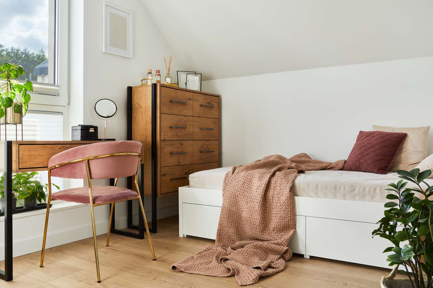 7 Inexpensive Hacks That Make Dorm Rooms Feel Ten Times Larger, Designers Say 10 Modern college dorm room with bed, table, chest of drawers, and pink velvet chair