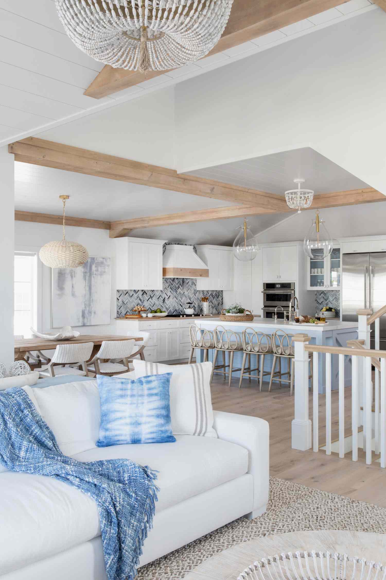 Die klassischen New England Color Combo -Designer werden diesen Sommer überall überall sein 12 Ein modernes offenes Wohnzimmer, Esszimmer und Küche mit blauem, weißem und hellbraunem Dekor, ein modernes Wohnzimmer der Küste