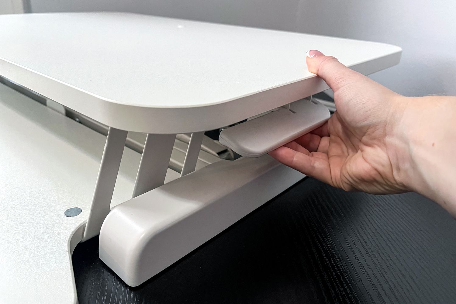 This Standing Desk Converter Is the Best Investment I Made for My WFH Setup—and It Boosts My Productivity 8 A person adjusting the Vivo 26-Inch Desk Converter, K Series