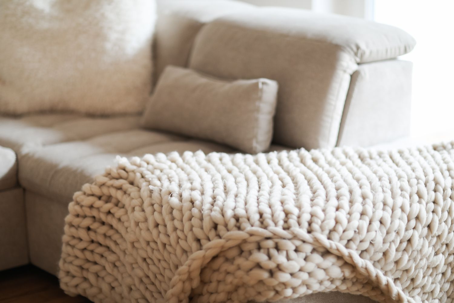 klobiger Strickwurf auf beige Couch