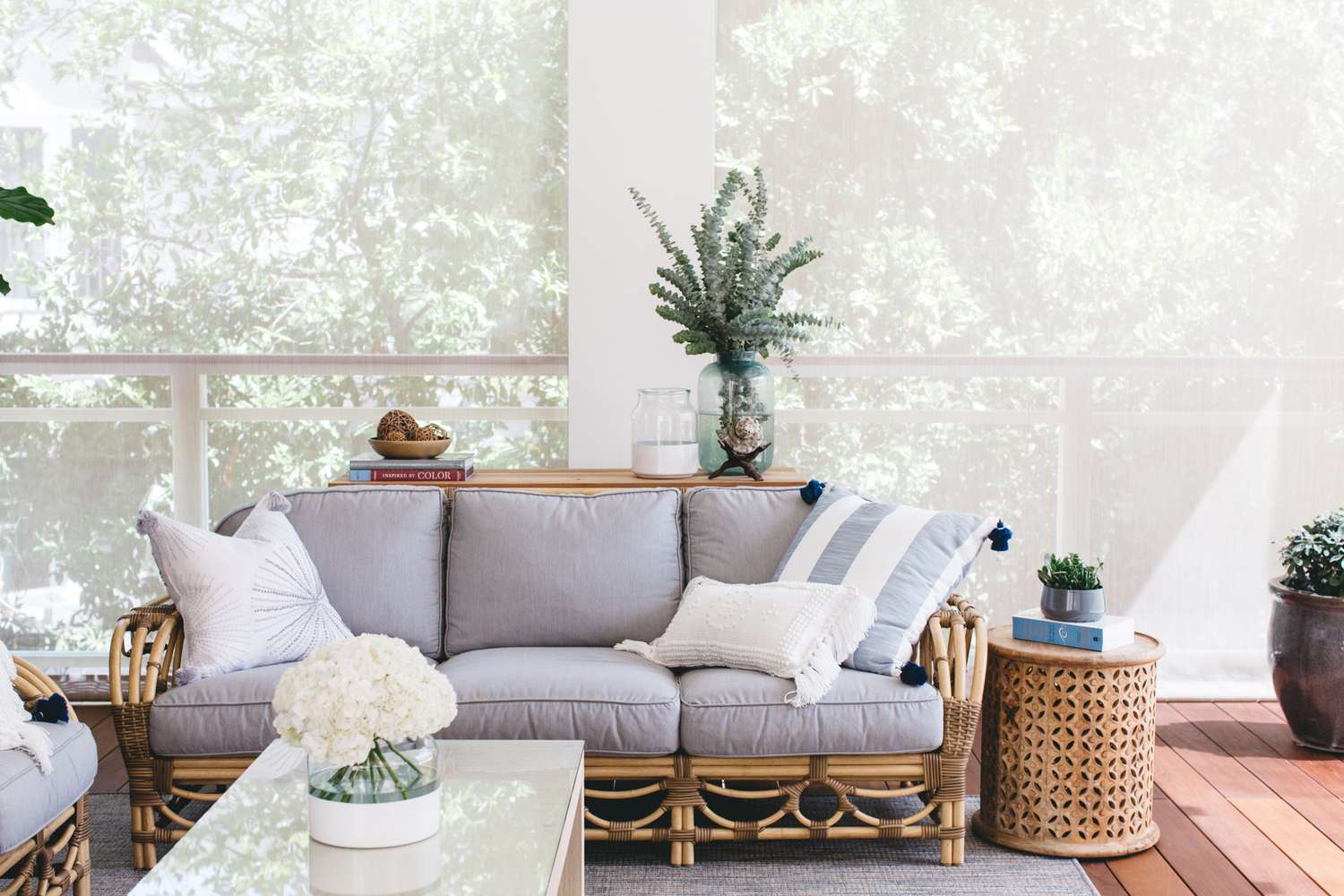 6 Easy Tips for a Stunning Outdoor Space That Designers Always Follow 2 Outdoor living room decorated with brown wicker and gray couch, throw pillows and houseplants