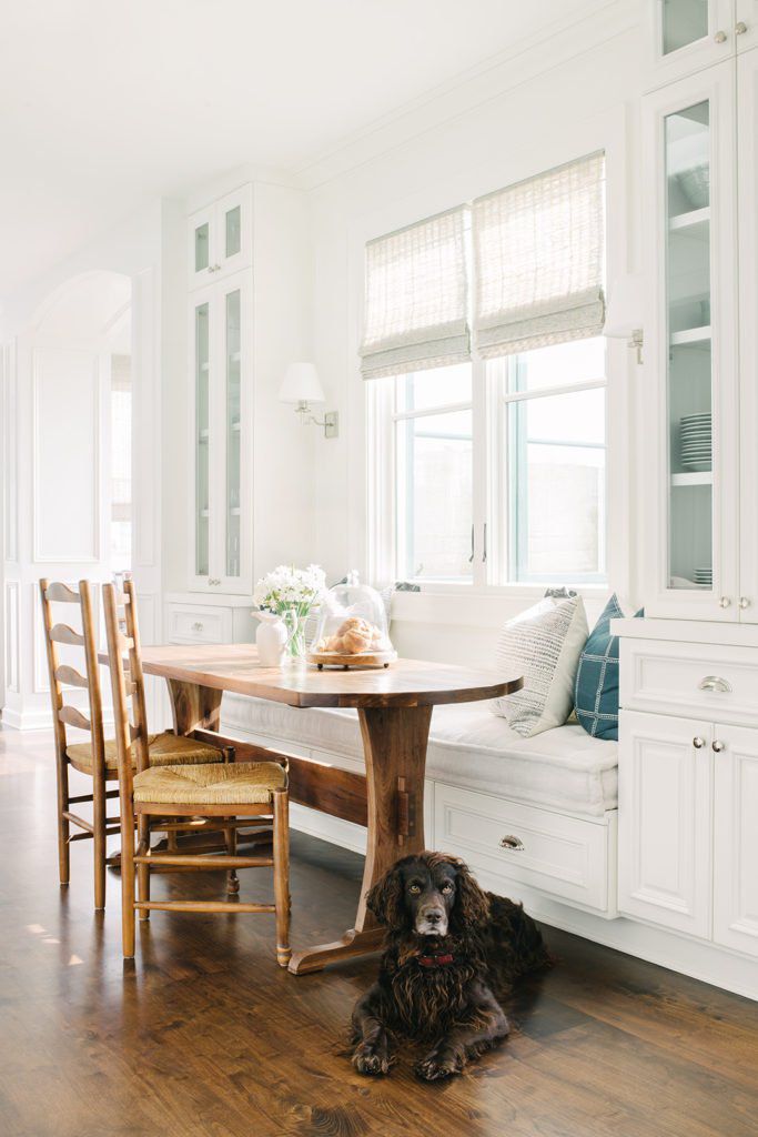 Die klassischen New England Color Combo -Designer werden diesen Sommer überall überall sein 10 Eine Frühstücksecke mit rustikalen Holzmöbeln, weißen Kissen und blau gedruckten Kissen