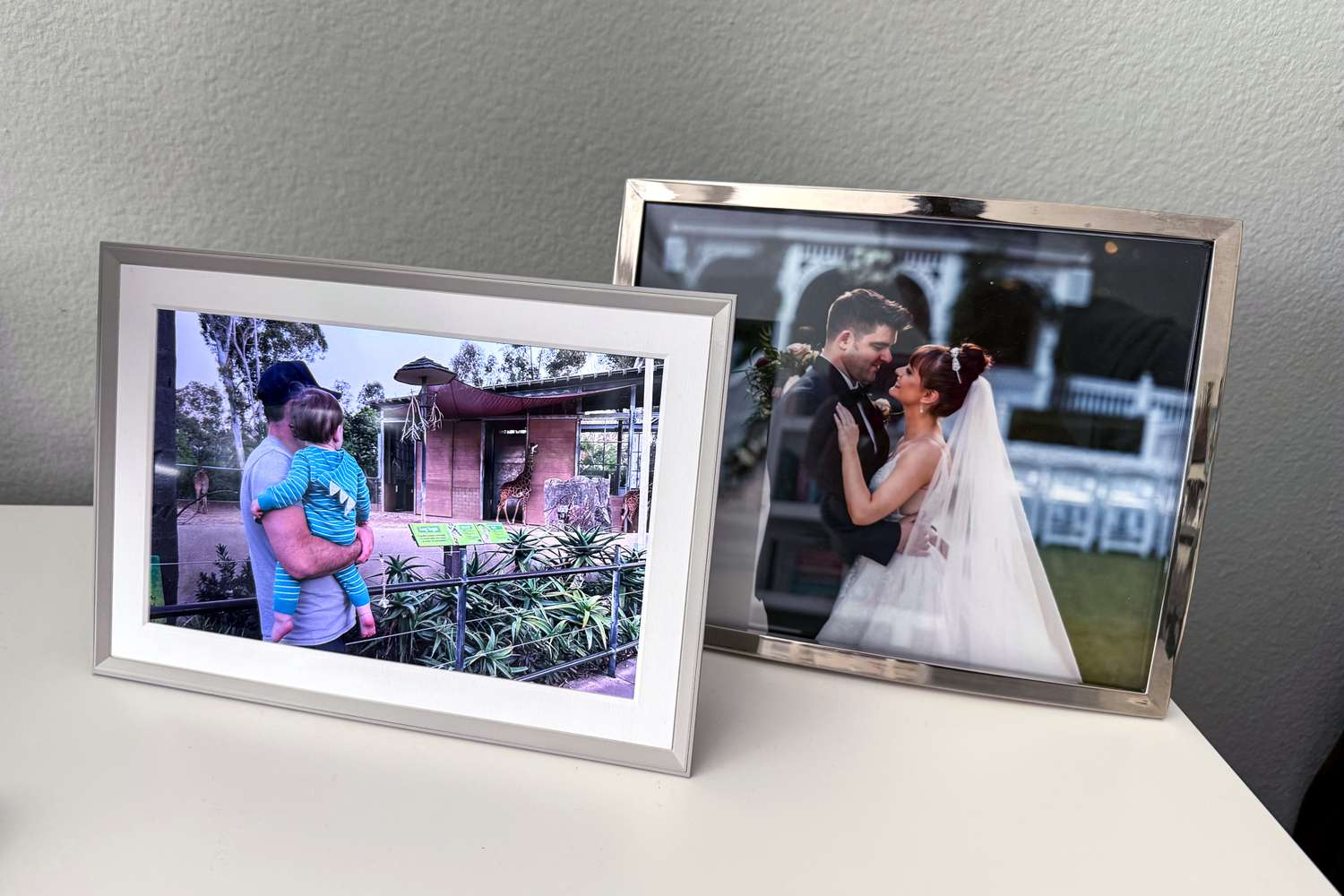 Der digitale Fotorahmen Aura Carver neben einem herkömmlichen Fotorahmen