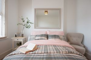 Weißes Schlafzimmer mit rosa und kariertem Bettwäsche
