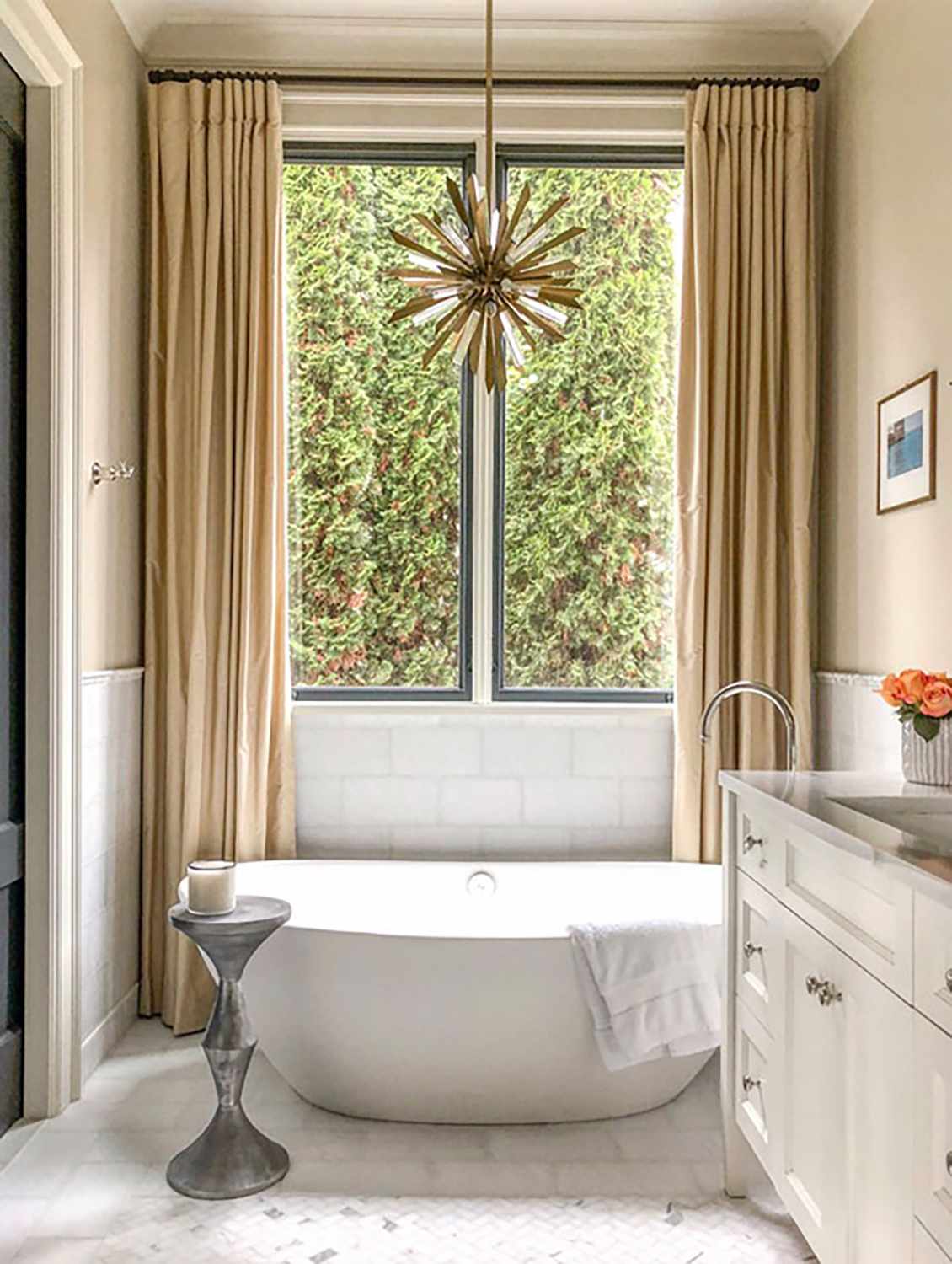 A starburst chandelier above a bathtub