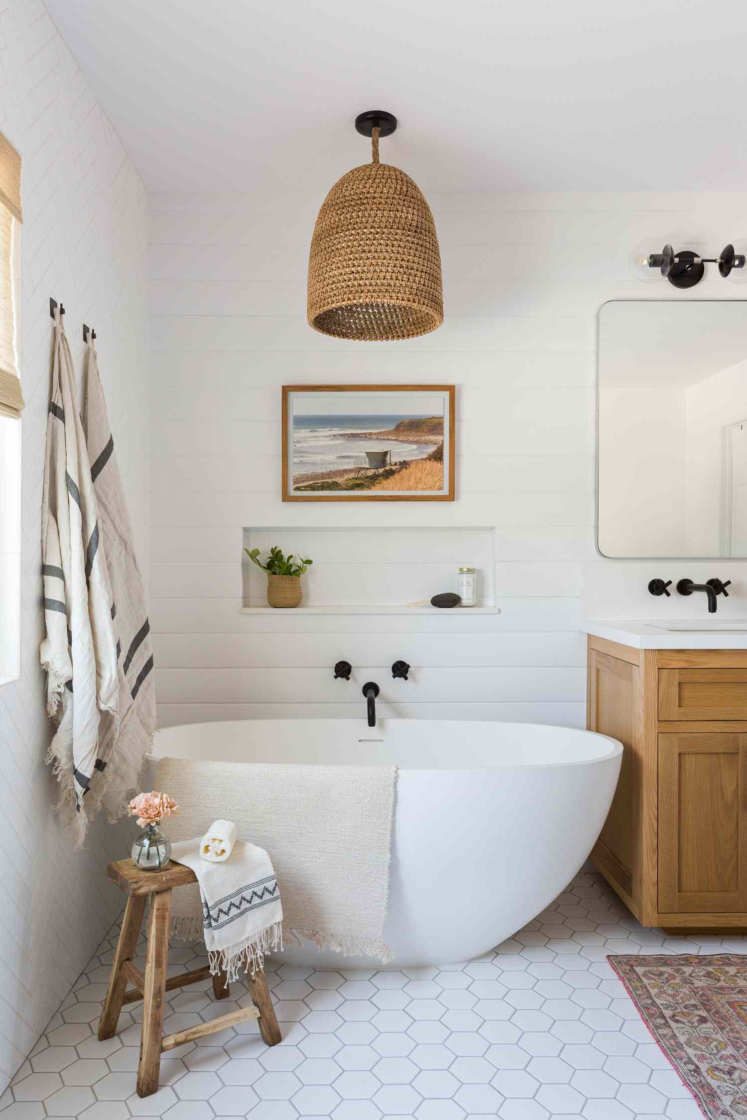 A beach print hanging above a bathtub