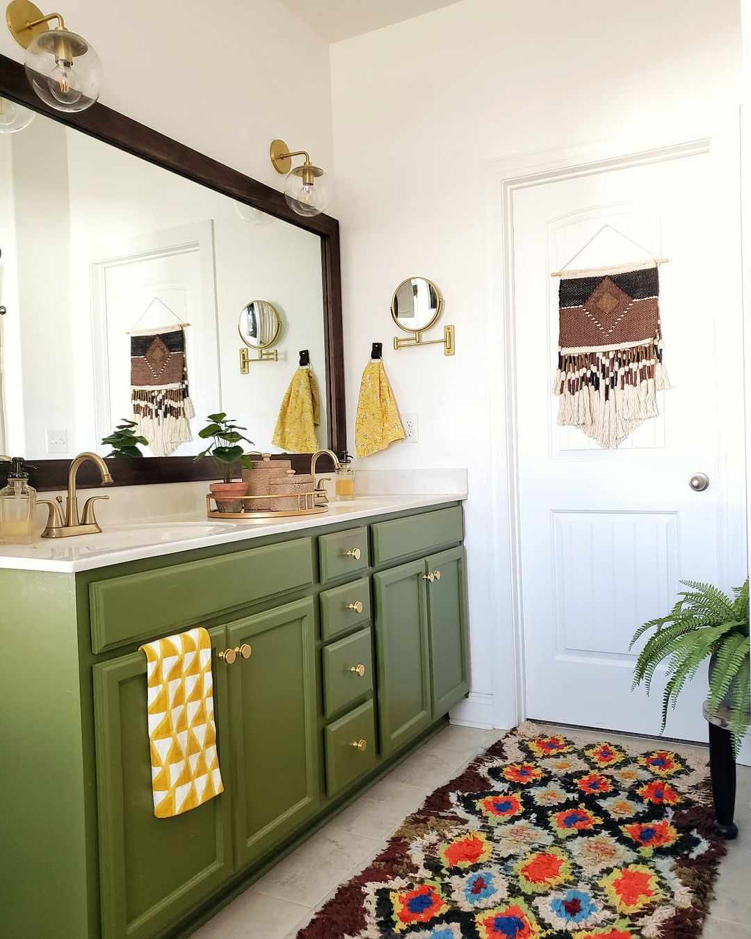 A bathroom with a green vanity and colorful accessories