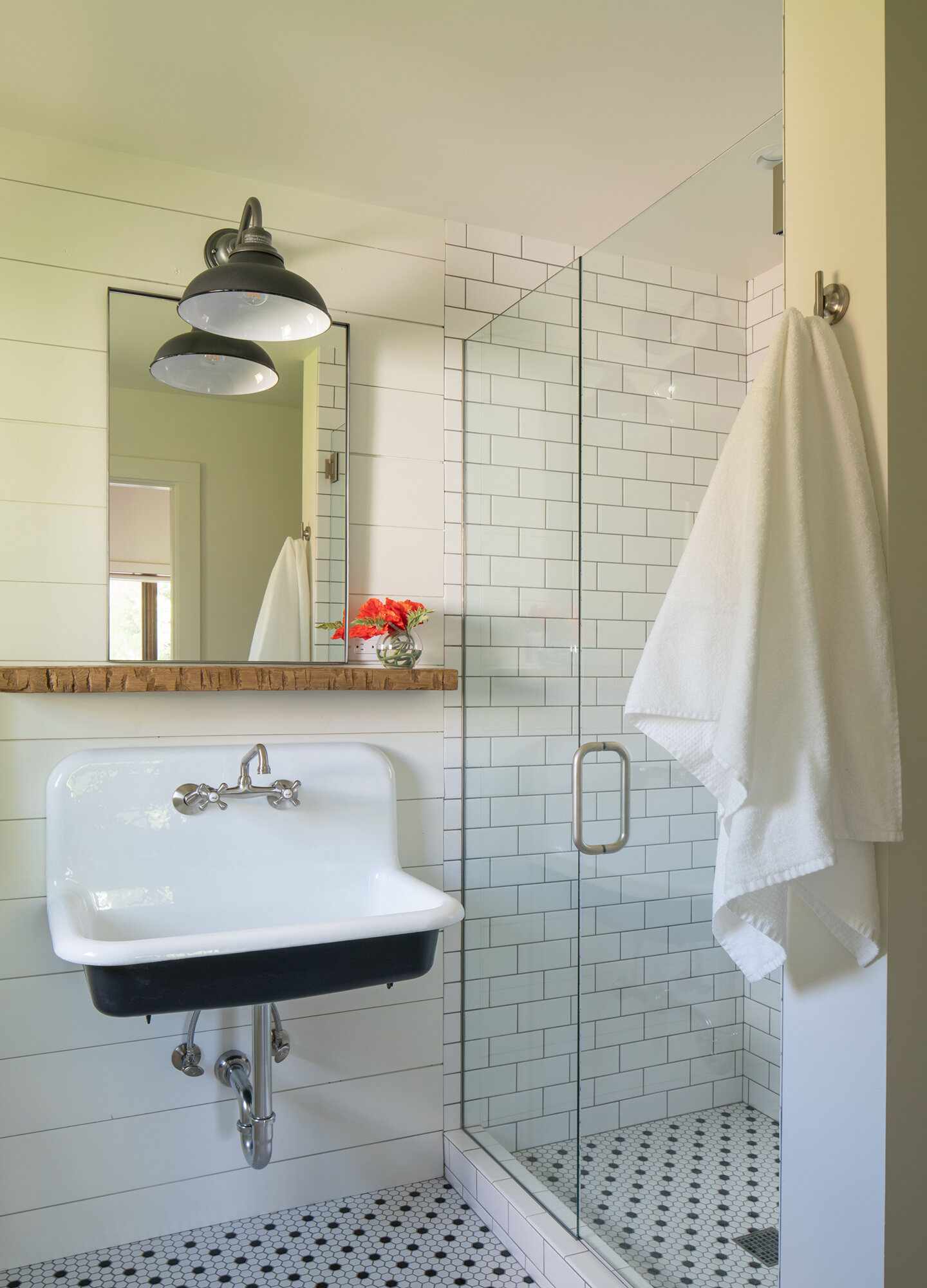 A floating wood shelf above a bathroom sink