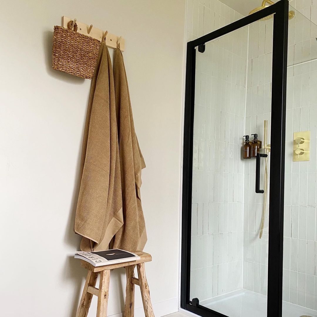 A coat rack used as a towel rack in a bathroom