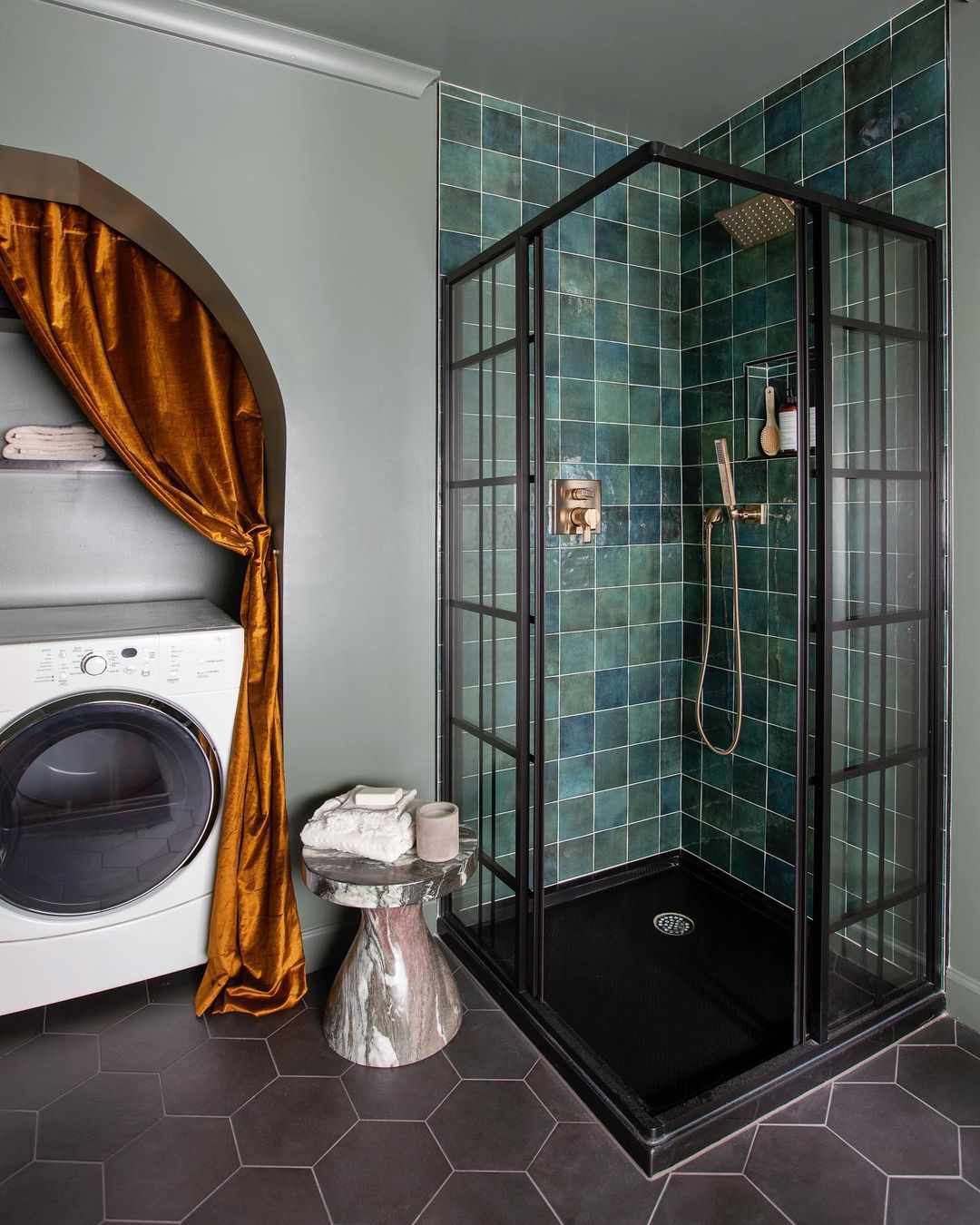A gold velvet curtain that conceals a washer and dryer in a bathroom
