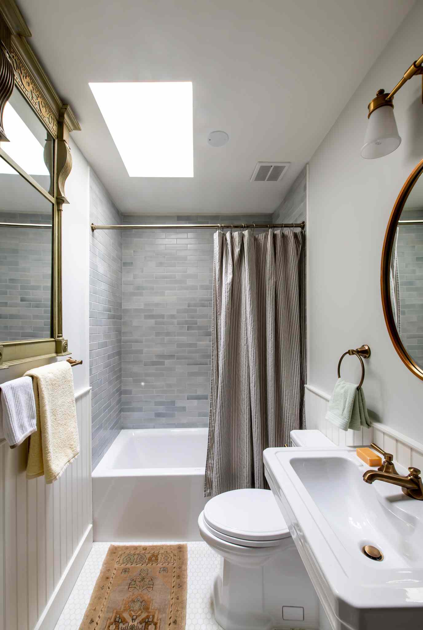 A large ornate mirror in a small bathroom