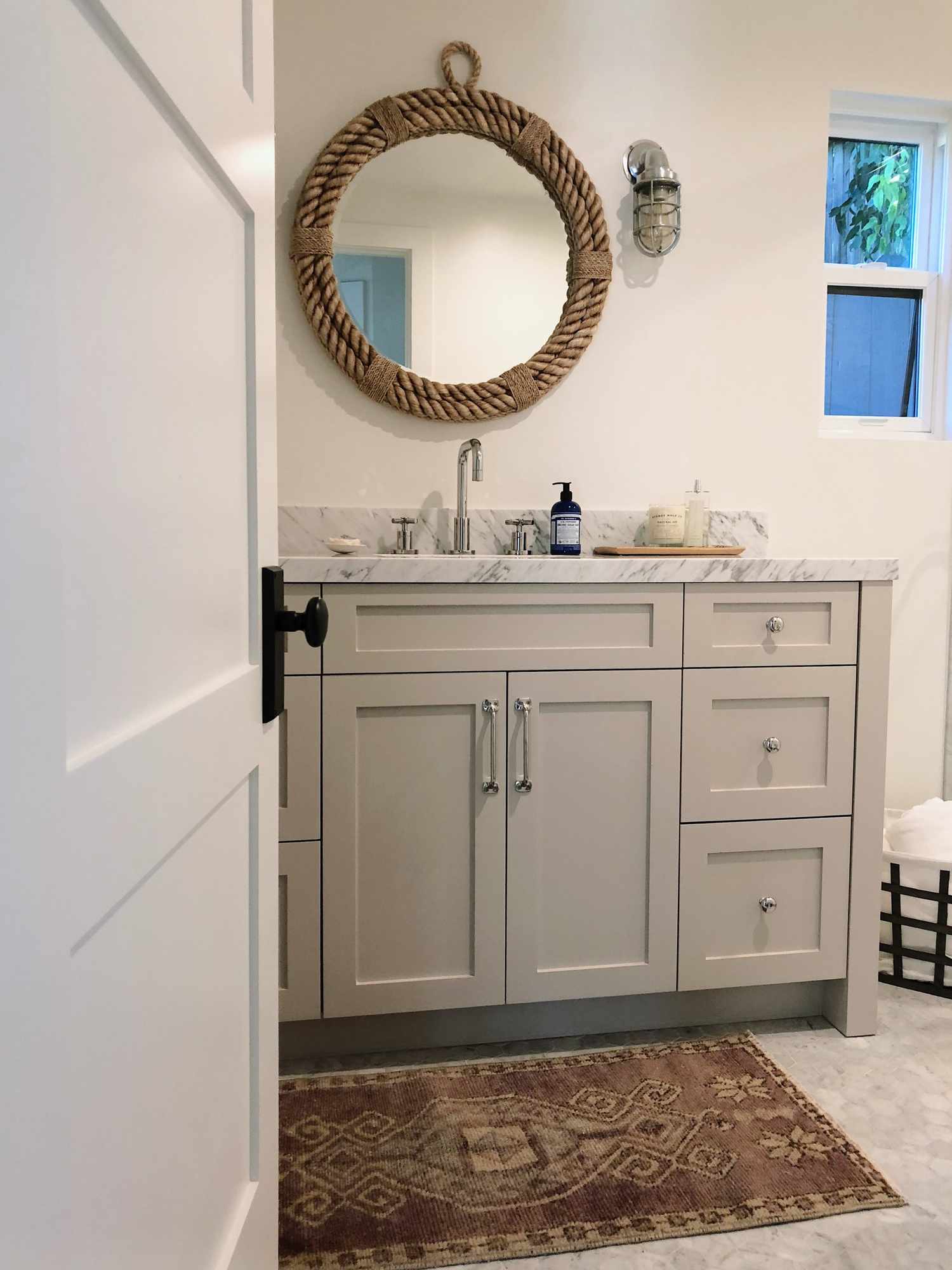 A neutral bathroom with a nautical rope mirror