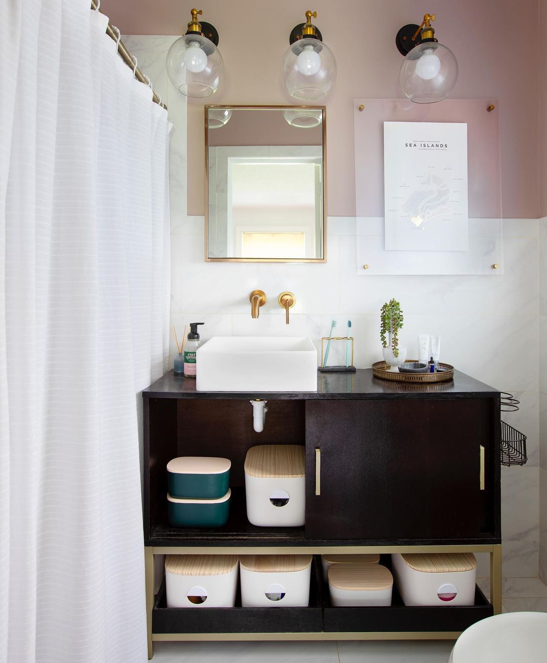 Stylish storage bins in a pink and white bathroom