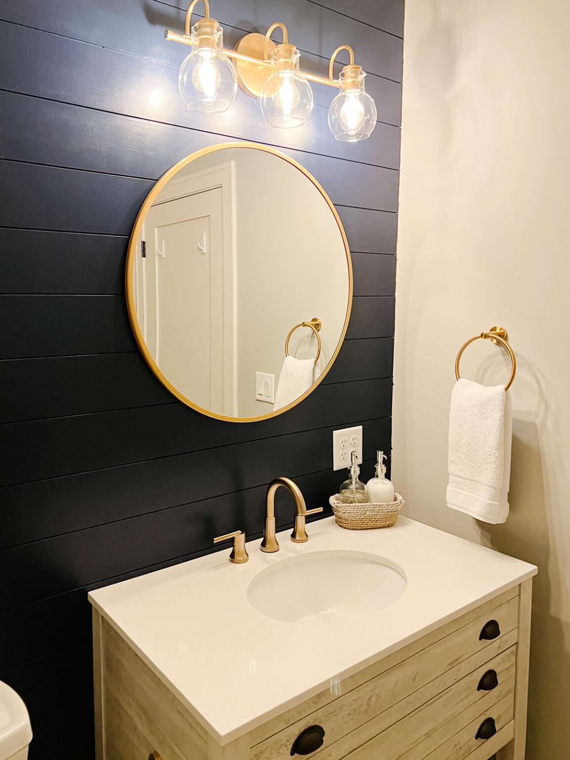 A bathroom with a navy blue accent wall