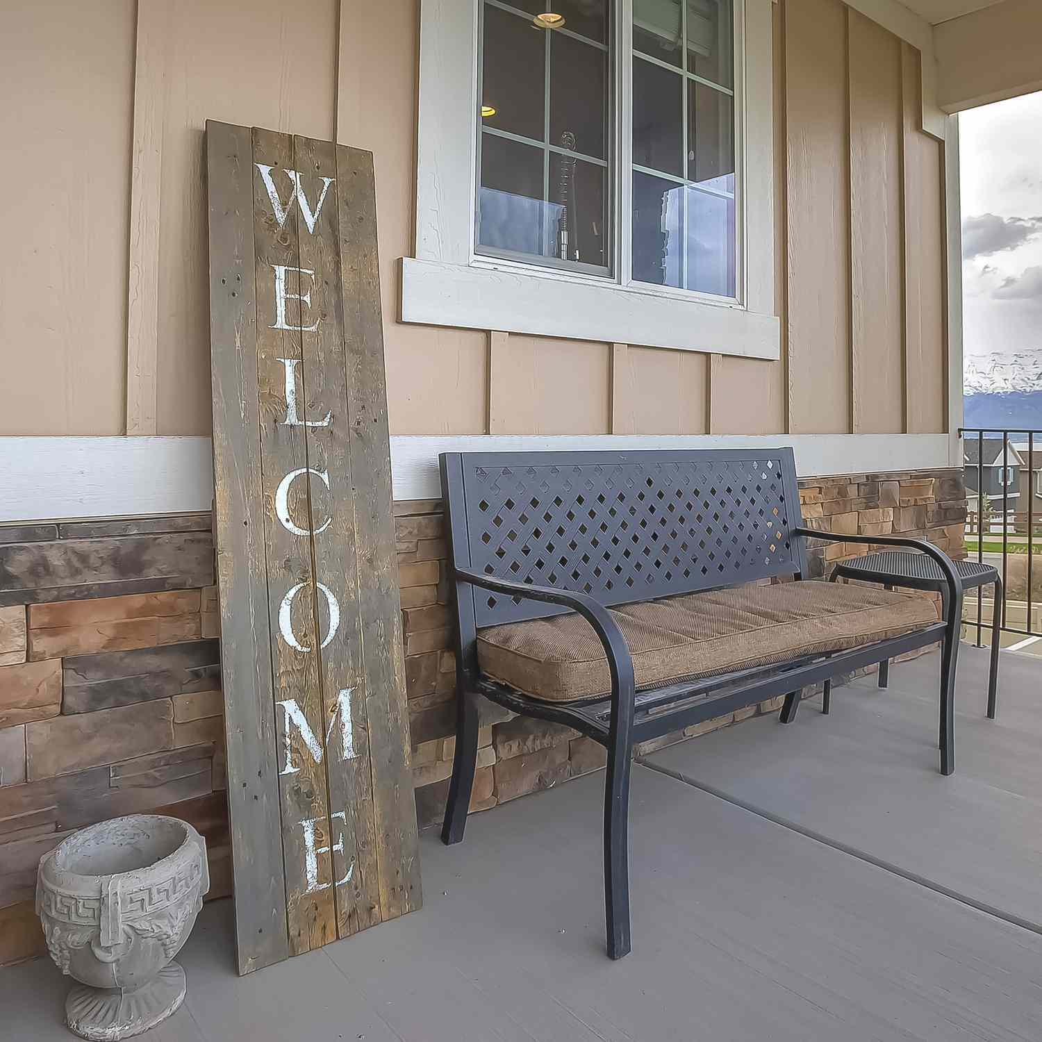 vertical wooden welcome sign on porch