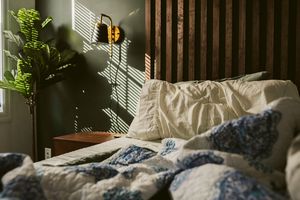 Bett mit launischer Beleuchtung im Schlafzimmer umgedreht