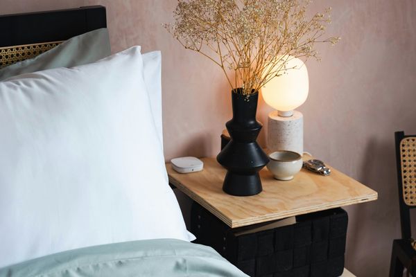 Bed with lamp and vase on bedside table