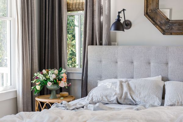 Dark and light gray light filtering curtains hanging near unmade bed