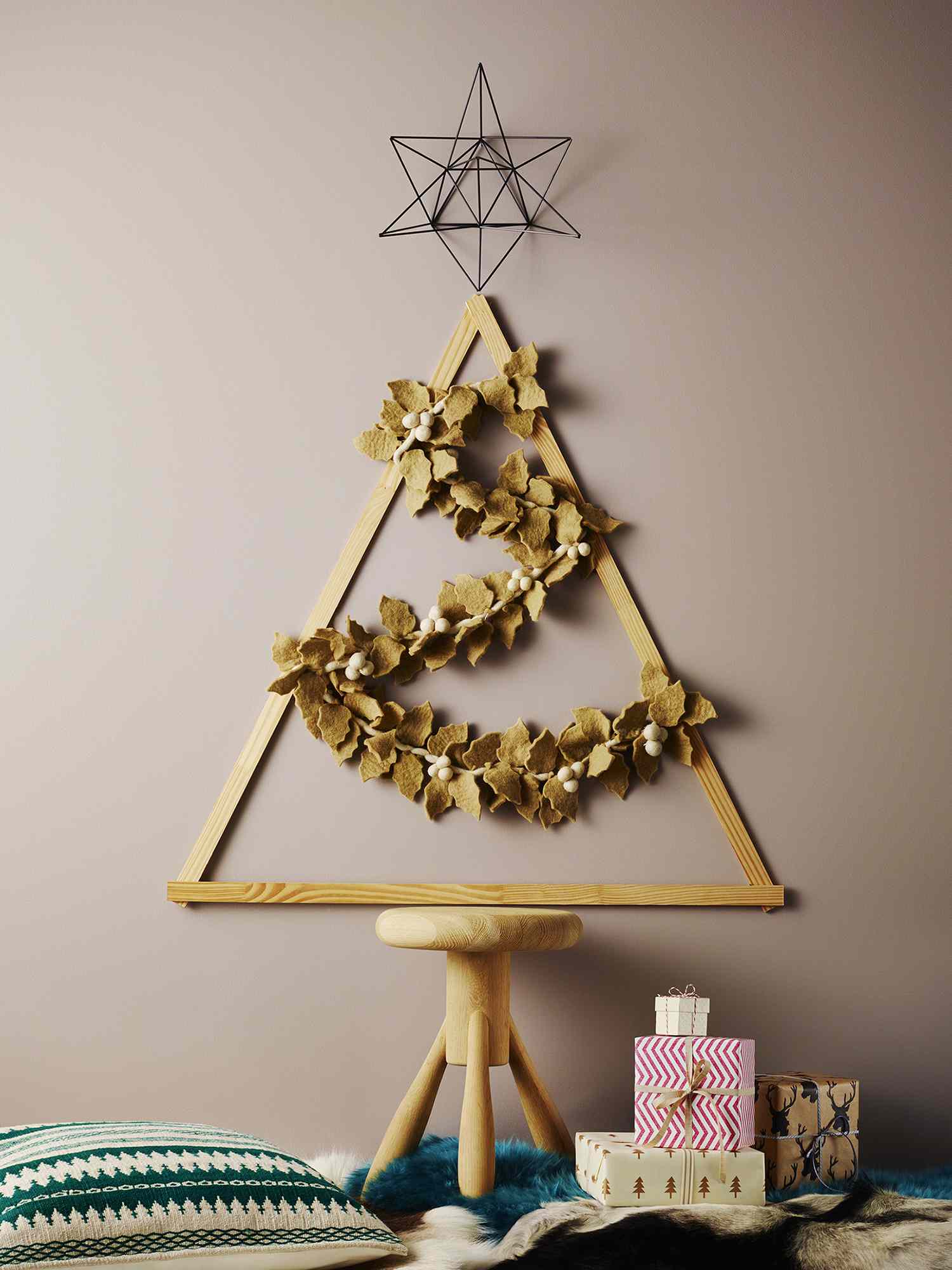 A wall mounted Christmas tree made with wooden sticks
