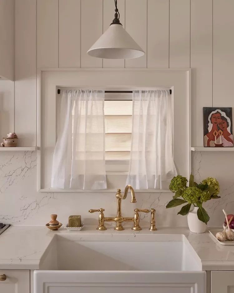 kitchen sink window with gauzy curtains