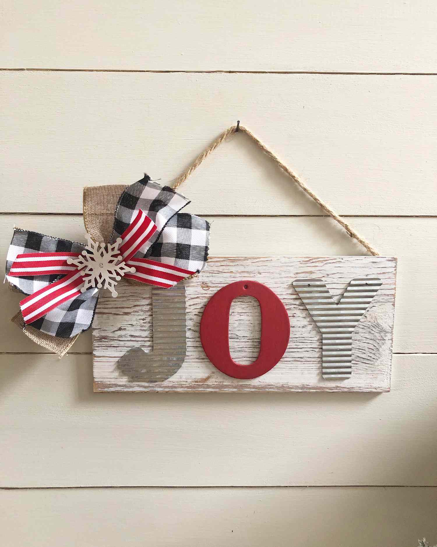 A DIY Christmas sign with a bow on it