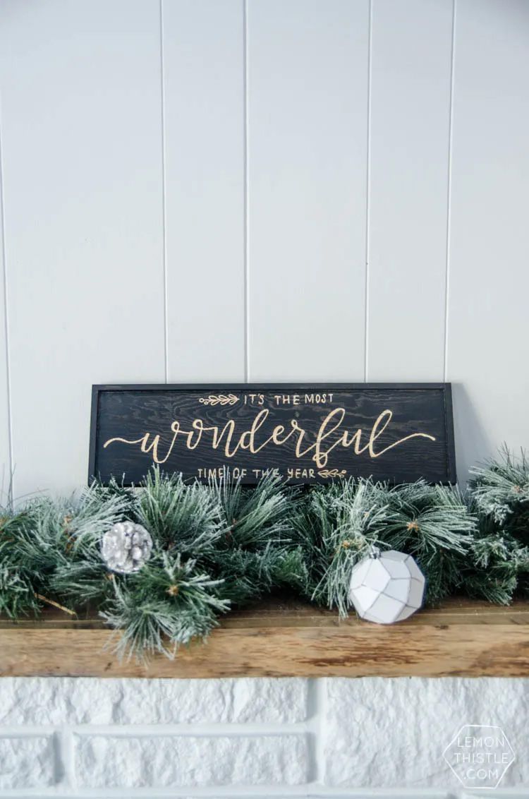 A black DIY Christmas sign on a mantle
