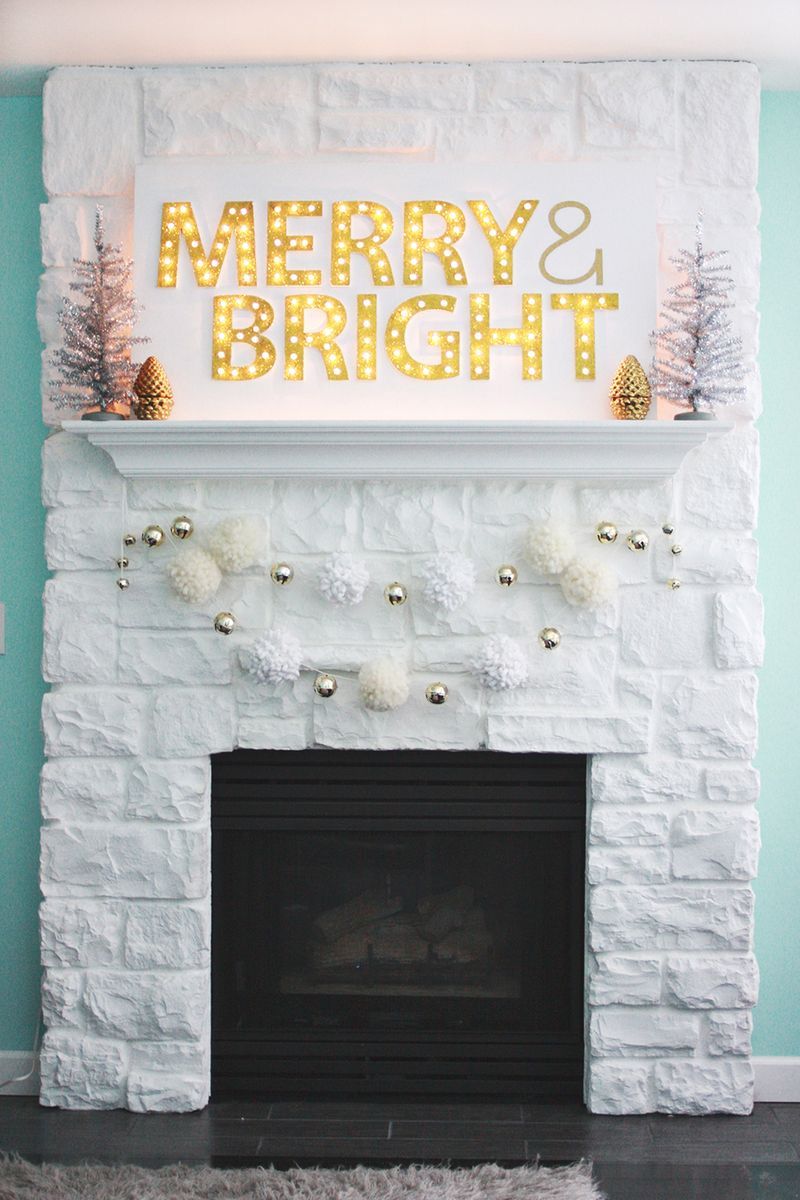 A DIY Christmas sign lit up with lights