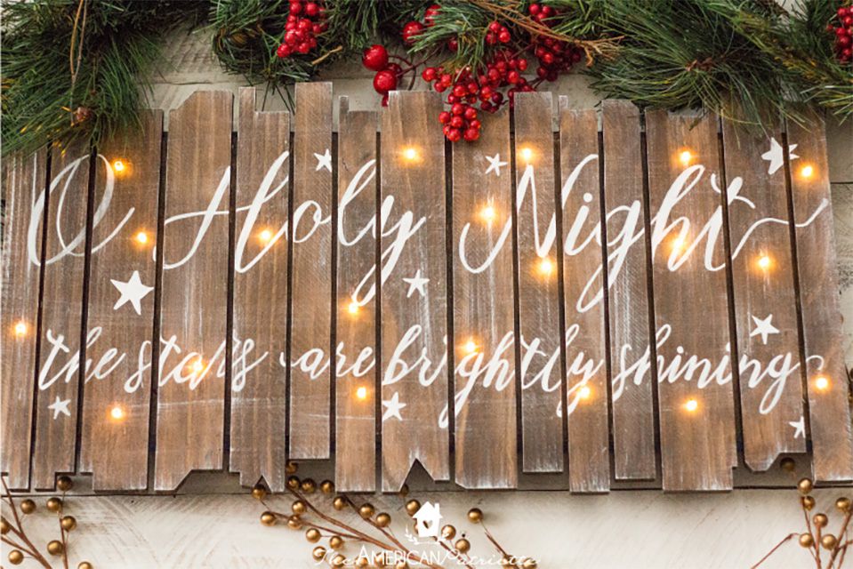 A wooden DIY Christmas sign with lights